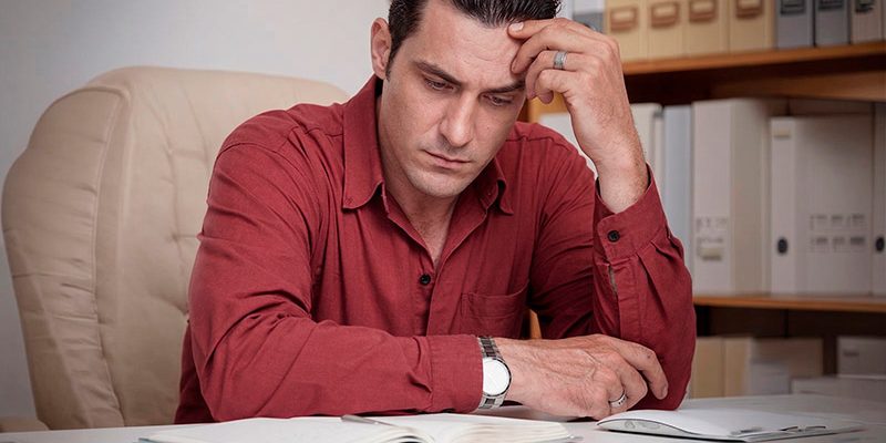 Adulto com dificuldade de concentração e desorganização refletindo sobre possível TDAH